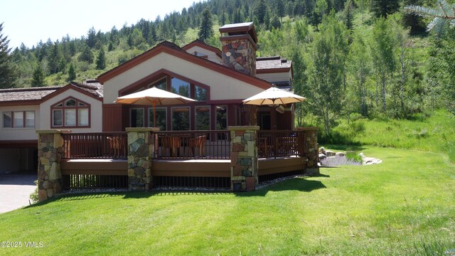 rear view of property featuring a yard and a deck