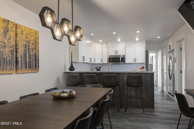 dining room with dark hardwood / wood-style flooring and sink