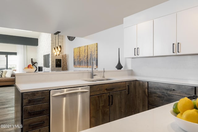 kitchen with pendant lighting, sink, white cabinetry, dark brown cabinets, and stainless steel dishwasher