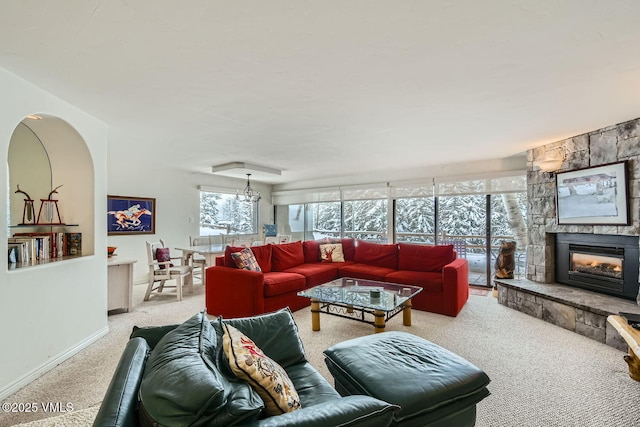 living area with baseboards, a fireplace, and light colored carpet