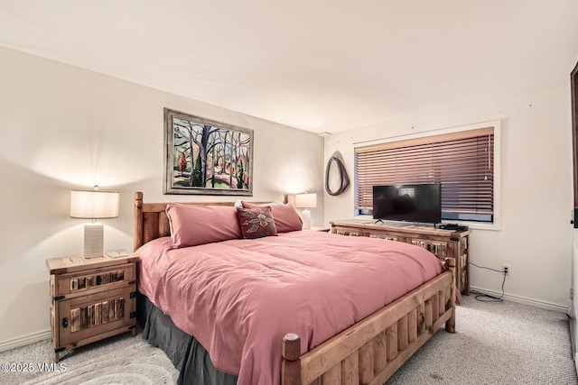 bedroom featuring baseboards and light colored carpet