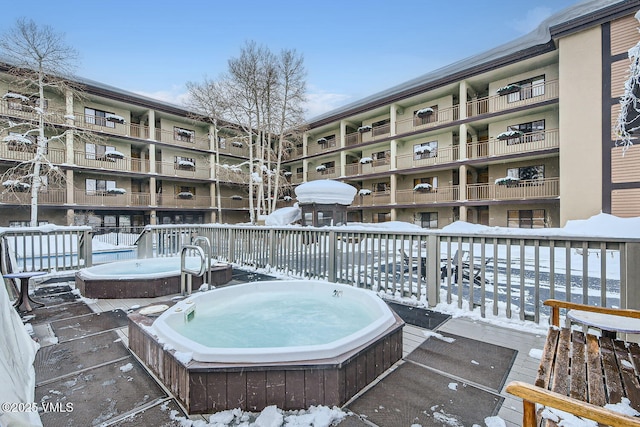 snow covered deck featuring an outdoor hot tub