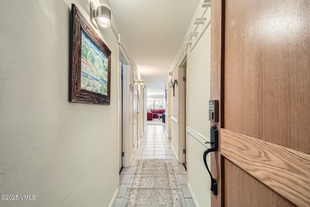 hallway with light tile patterned floors, a barn door, and a textured wall