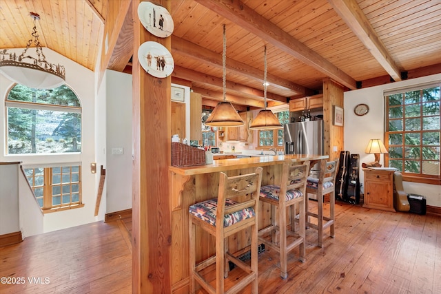 kitchen featuring light countertops, beamed ceiling, wooden ceiling, and light wood-style flooring