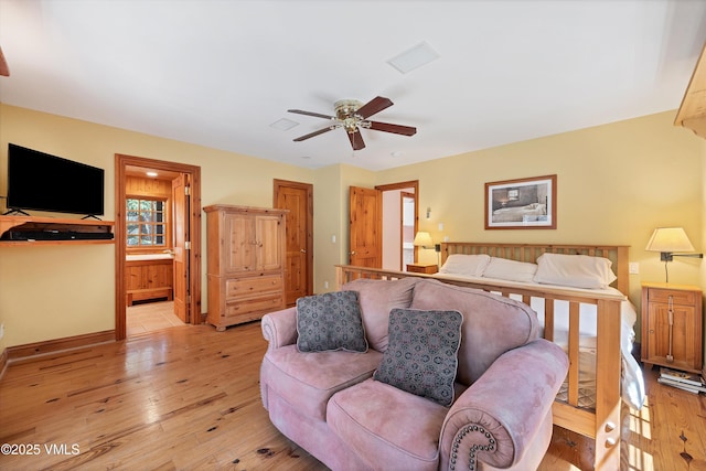 bedroom with ensuite bathroom, a ceiling fan, light wood finished floors, and baseboards