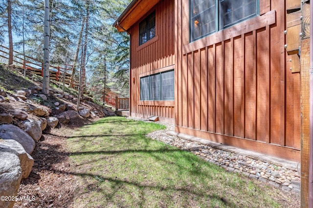 view of property exterior with board and batten siding and a yard