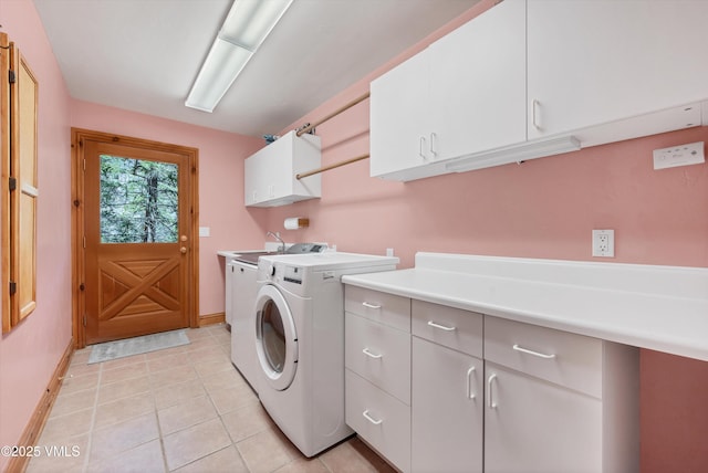 clothes washing area with baseboards, cabinet space, light tile patterned floors, and washing machine and dryer