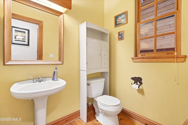 bathroom featuring baseboards, toilet, and wood finished floors