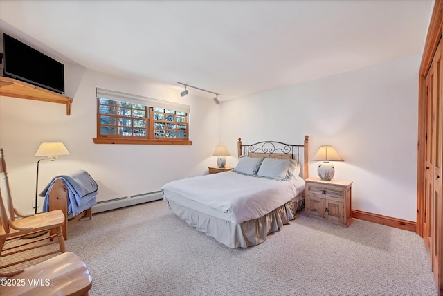carpeted bedroom featuring a baseboard heating unit and track lighting