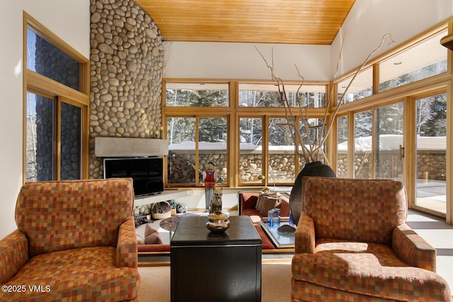 sunroom with plenty of natural light, a fireplace, and wood ceiling