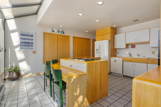 kitchen with white cabinetry, sink, white appliances, and a kitchen island