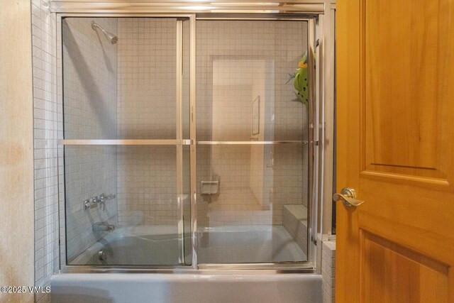 bathroom with bath / shower combo with glass door