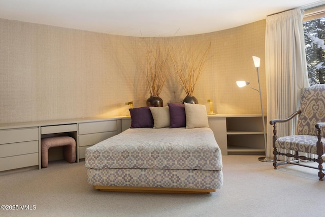 bedroom featuring light carpet and built in desk