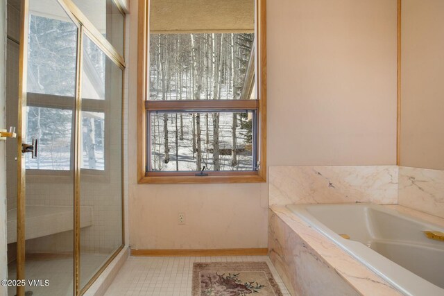 bathroom with tile patterned flooring and shower with separate bathtub