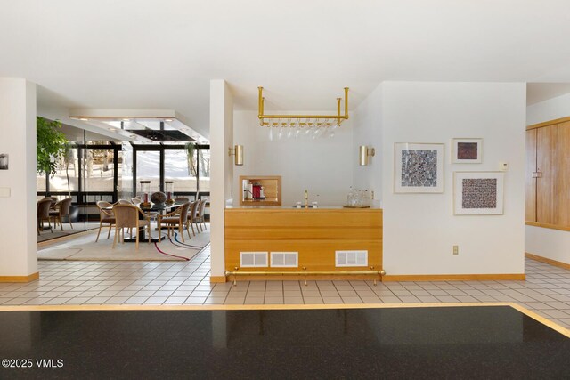 interior space with sink, expansive windows, and light tile patterned flooring