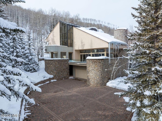 view of snow covered exterior with a garage