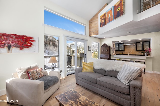 4524 Meadow Dr Unit 905, Vail, CO 81657 - living area with high vaulted ceiling, light wood-style flooring, and baseboards