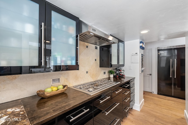 4524 Meadow Dr Unit 905, Vail, CO 81657 - kitchen with high end refrigerator, dark countertops, stainless steel gas cooktop, range hood, and light wood finished floors
