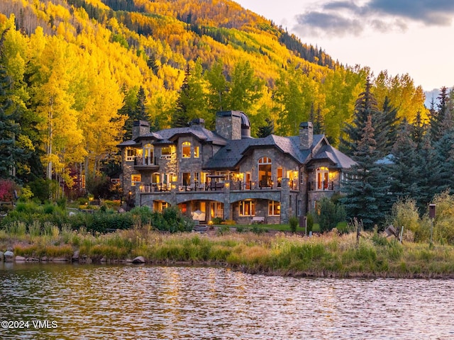 rear view of house with a water and mountain view