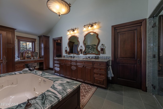 bathroom featuring vaulted ceiling, vanity, tile patterned flooring, and a washtub