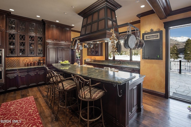 bar with crown molding, dark brown cabinets, dark hardwood / wood-style floors, and decorative backsplash