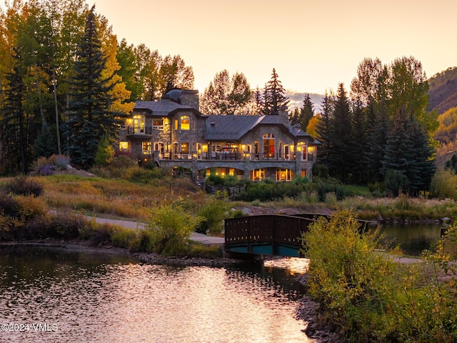 back house at dusk with a water view