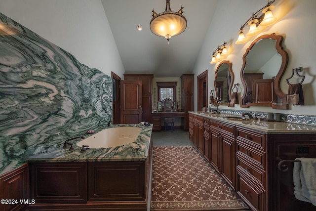 bathroom featuring vanity, a bath, and vaulted ceiling