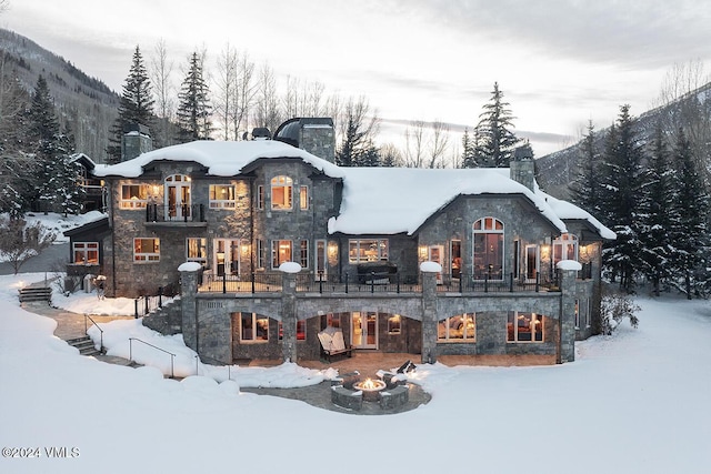 exterior space with a mountain view, a fire pit, and a balcony