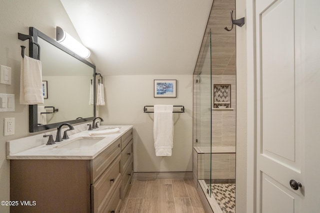 4031 Bighorn Rd Unit 9-H, Vail, CO 81657 - full bathroom featuring vaulted ceiling, double vanity, a shower stall, and wood finished floors