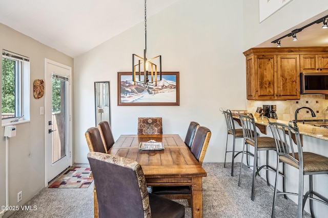4031 Bighorn Rd Unit 9-H, Vail, CO 81657 - dining room with rail lighting, light floors, vaulted ceiling, and a chandelier