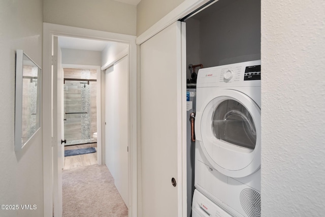 4031 Bighorn Rd Unit 9-H, Vail, CO 81657 - laundry room featuring stacked washer and clothes dryer and carpet flooring