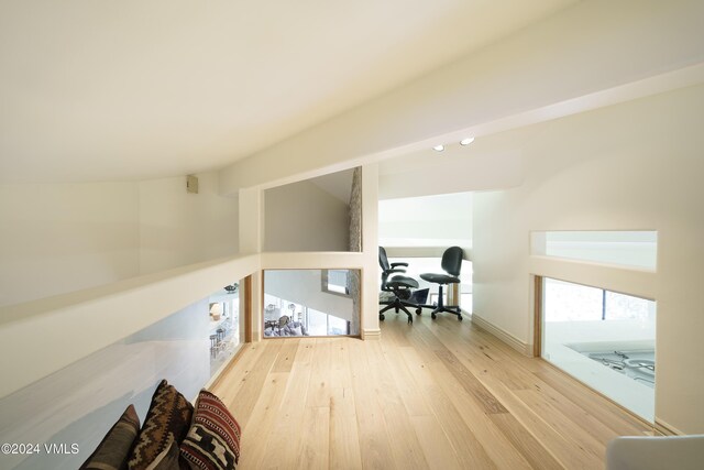 interior space with lofted ceiling, baseboards, and wood finished floors