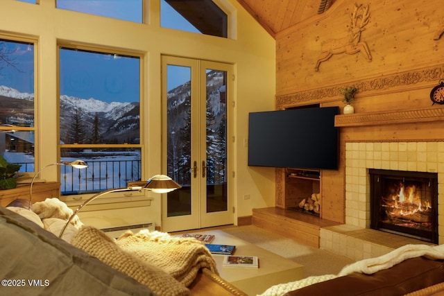 carpeted living room with a tiled fireplace, vaulted ceiling, and baseboard heating