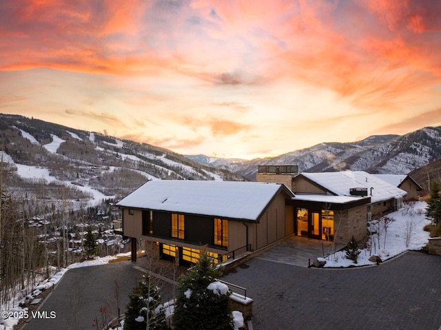 view of front of property with a mountain view and driveway