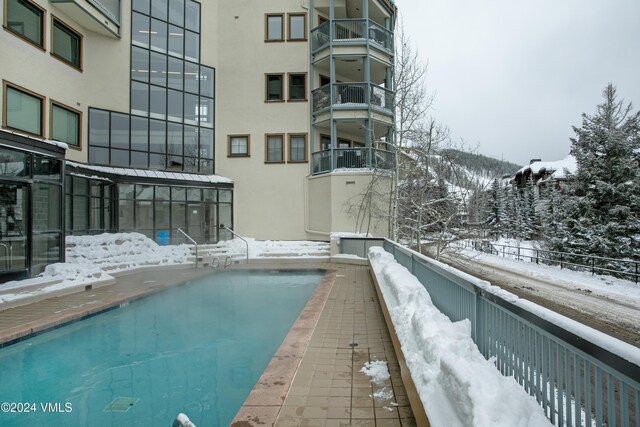 snow covered pool featuring a mountain view