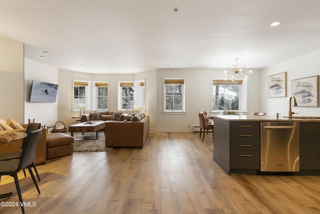 kitchen featuring sink, stainless steel dishwasher, a chandelier, and light hardwood / wood-style flooring