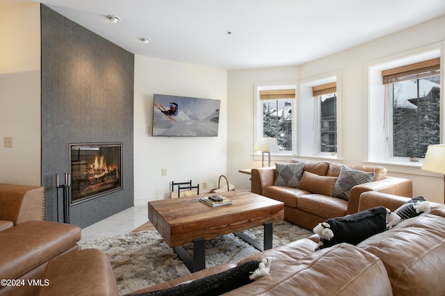 living room featuring a wealth of natural light and a large fireplace