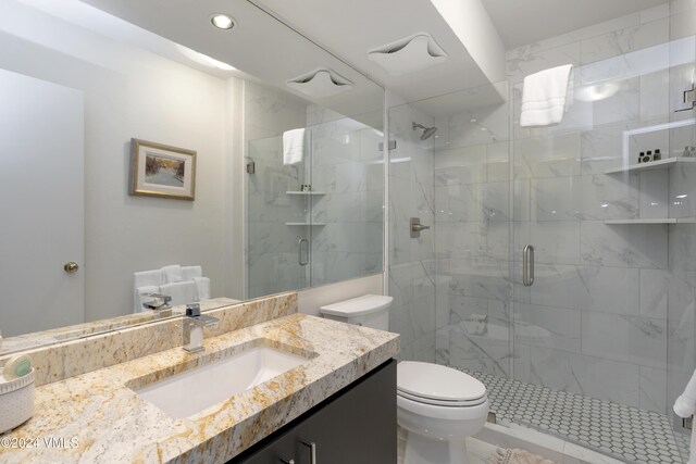 bathroom with vanity, toilet, and a shower with shower door