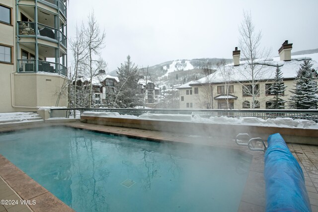 snow covered pool with a mountain view