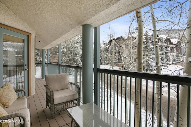 view of snow covered back of property