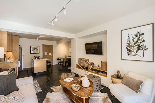 living area with baseboards and dark tile patterned flooring