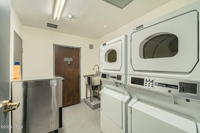 shared laundry area featuring stacked washer / drying machine, independent washer and dryer, visible vents, and a sink