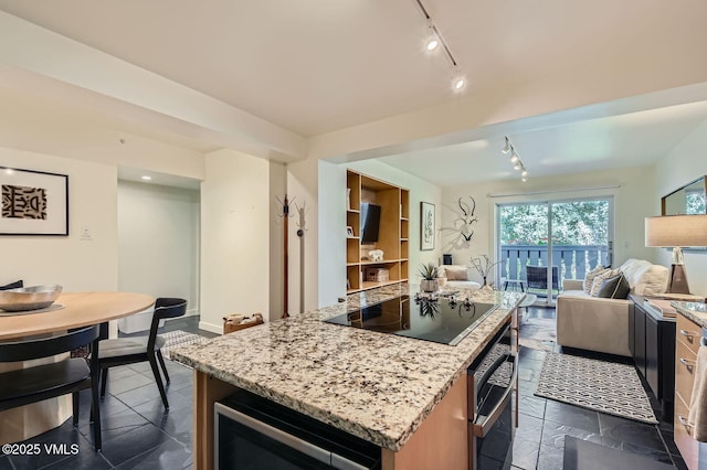 9 Vail Rd Unit 16, Vail, CO 81657 - kitchen featuring track lighting, open floor plan, black electric cooktop, and light stone counters