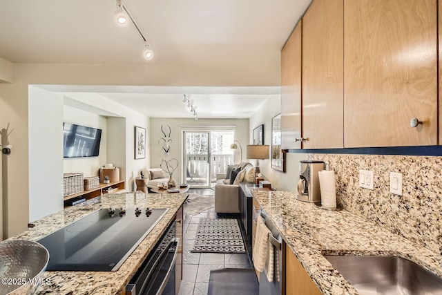 kitchen featuring tasteful backsplash, open floor plan, light stone countertops, stainless steel appliances, and track lighting