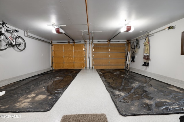 garage featuring a garage door opener and baseboards