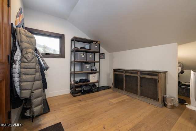 interior space with lofted ceiling, baseboards, and light wood finished floors