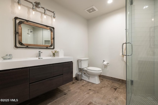 full bath with wood finished floors, visible vents, baseboards, a stall shower, and toilet