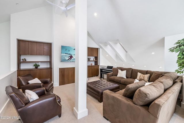 living area featuring a ceiling fan, light colored carpet, and high vaulted ceiling