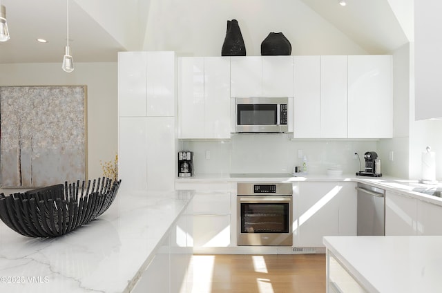 kitchen featuring stainless steel appliances, backsplash, modern cabinets, and white cabinetry