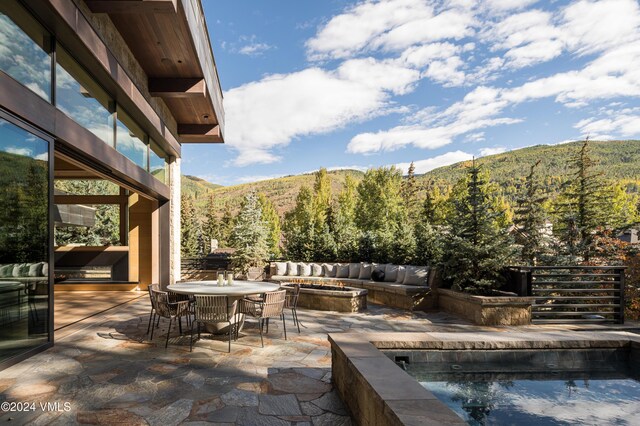 100 Vail Rd, Vail, CO 81657 - view of swimming pool with an outdoor fire pit, a patio area, a mountain view, and a wooded view
